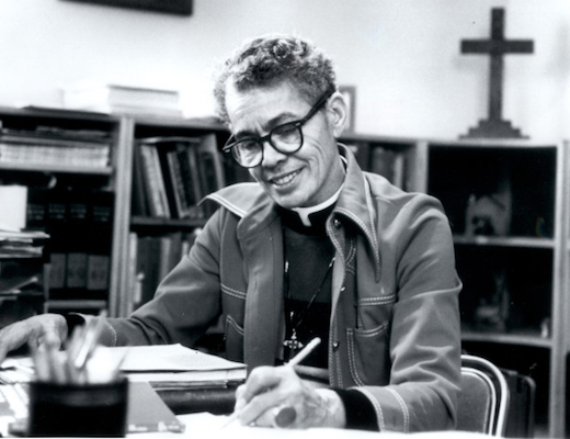 Black and white photo of Pauli Murray sitting at a desk in a library.